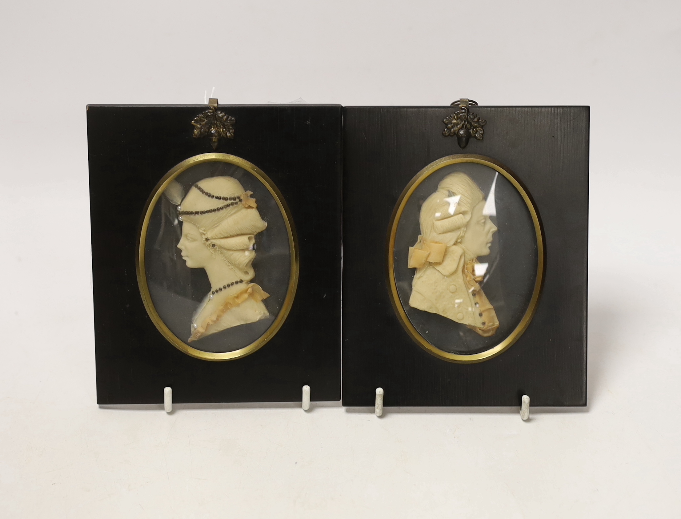Attributed to Leslie Ray, pair of 20th century wax relief portraits of a lady and gentleman wearing 18th century dress, 15cm high including the frame